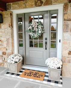 two planters with flowers on the front porch next to a door that says, you say when it's 4 bad things