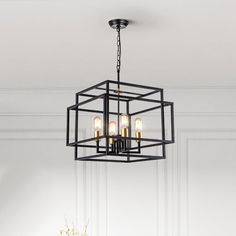 a chandelier hanging from the ceiling in a room with white walls and flooring