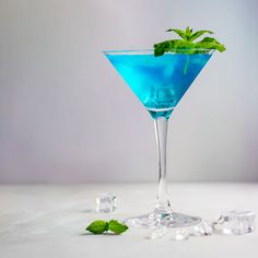 a blue cocktail with mint garnish and ice cubes