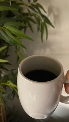 a person holding a cup of coffee in their hand