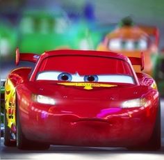 the character cars from disney pixars is driving down the road with another car behind him