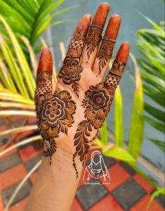 a woman's hand with henna tattoos on it