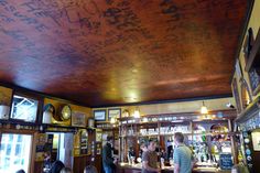 people are standing at the bar with many writing on the ceiling