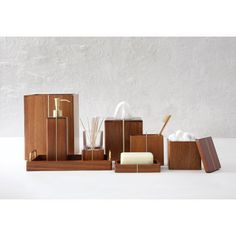 wooden bathroom accessories including soap, toothbrushes and other items on a white surface