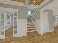 an empty living room with stairs leading up to the second floor