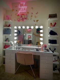 a vanity with lights, mirror and chair in front of the desk is decorated with pink flowers