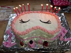 a birthday cake with candles sticking out of it's face and eyes on tin foil