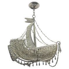 a chandelier hanging from the ceiling with a sailboat on it's side