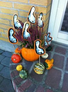 pumpkins, gourds and other decorations are arranged on the front porch for halloween