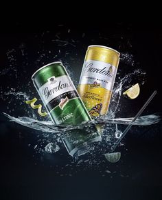 three cans of corona beer are splashing into the water with lemon wedges on top