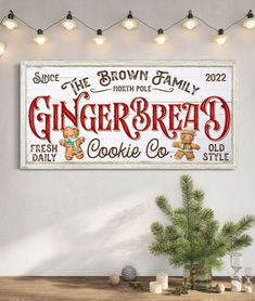 a gingerbread sign hanging on the wall next to a christmas tree