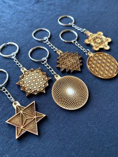 six key chains with different shapes and sizes on blue fabric, one has an ornament in the middle