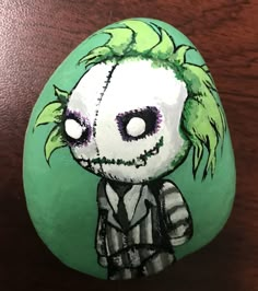 a painted rock with a creepy clown on it