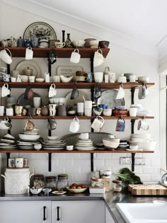 a shelf filled with lots of dishes and cups