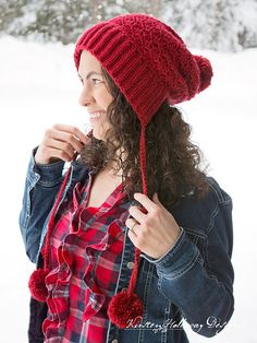 a woman wearing a red hat while standing in the snow