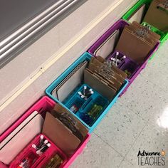 several different colored boxes are lined up on the floor