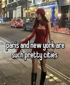 a woman in a red dress and black boots is walking down the street with her hat on