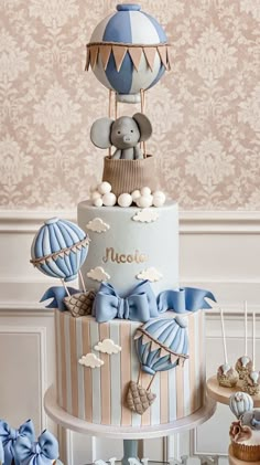 a three tiered cake decorated with blue and white decorations on top of a table