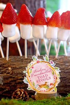 strawberries and marshmallows are on sticks in front of a forest theme