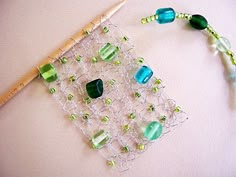 a piece of glass beaded with green and blue beads