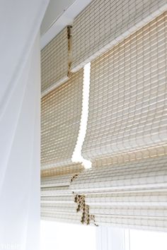 an open window with blinds hanging from it's side