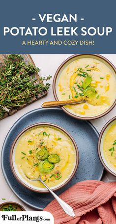 three bowls of vegan potato leek soup on a blue plate with spoons