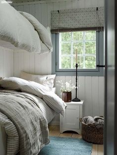 a bed room with a neatly made bed next to a window