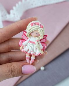 a small doll is sitting on someone's finger