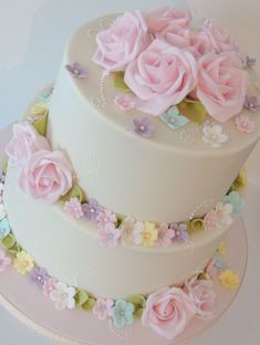 a three tiered cake decorated with pink and blue flowers