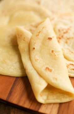 three tortillas on a wooden cutting board