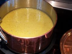 there is a pot on the stove with some food in it and two spoons next to it