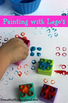 a child is painting with lego's on the paper and some cupcakes