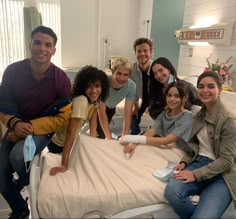 a group of people posing for a photo in a hospital room with an oxygen tube on the bed