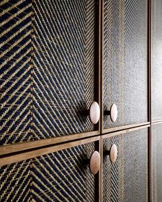 three wooden drawers with knobs on them in a room filled with wood and plaid wallpaper