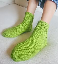 a person sitting on a couch wearing green socks