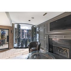 a living room filled with furniture and a wine rack on the wall next to a fireplace