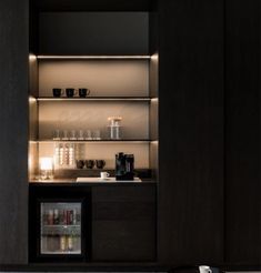 an open cabinet in the middle of a room with cups and glasses on it's shelves