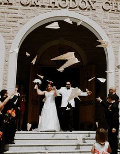 a bride and groom are throwing paper in the air at their wedding ceremony on steps