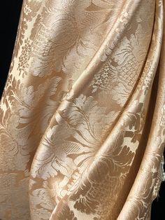 an image of a gold and white fabric with floral design on the bottom, as if it were brocaded