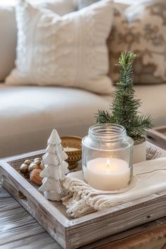 a tray with a candle, pine tree and other decorations sitting on top of it