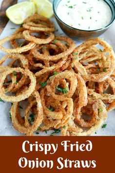 crispy fried onion straws with ranch dip and lemon wedges on the side