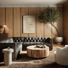 a living room with wood paneling and black leather couches in the center table