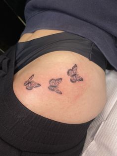 a woman's stomach with three butterflies tattoo on her side ribcaulitis