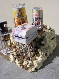 two ice cream dispensers sitting on top of a pile of dirt