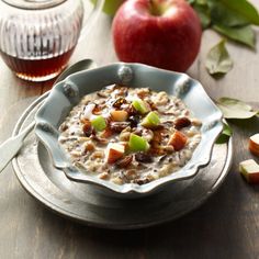 a bowl of oatmeal with apples next to it