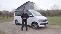 a man standing in front of a white van with an awning on it's roof