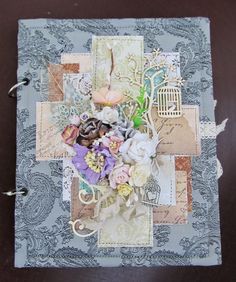 an altered book with flowers and birdcage