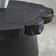 a close up of a tree stump table with a cup on it's top