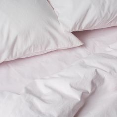 white pillows and blankets are piled on top of each other