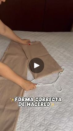 a woman laying on top of a bed next to a brown bag with an electrical cord